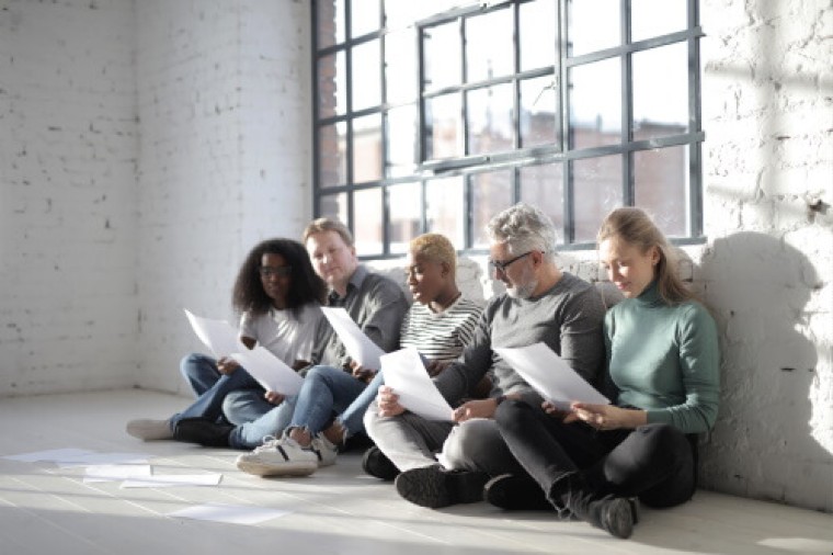 an illustration of candidates holding their resumes sitting under a window